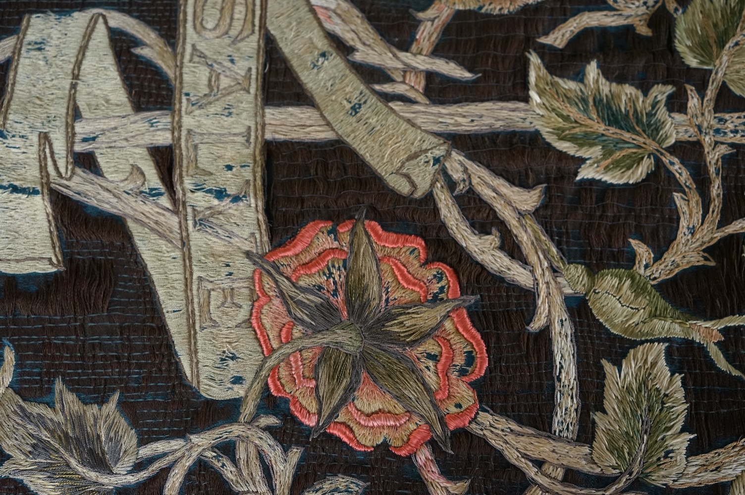 A large Arts and Crafts silk embroidered wall hanging, embroidered in the manner of May Morris with a large central scrolling flowering rose tree and banner embroidered with Salve and a two row motto below;, Rose leaves